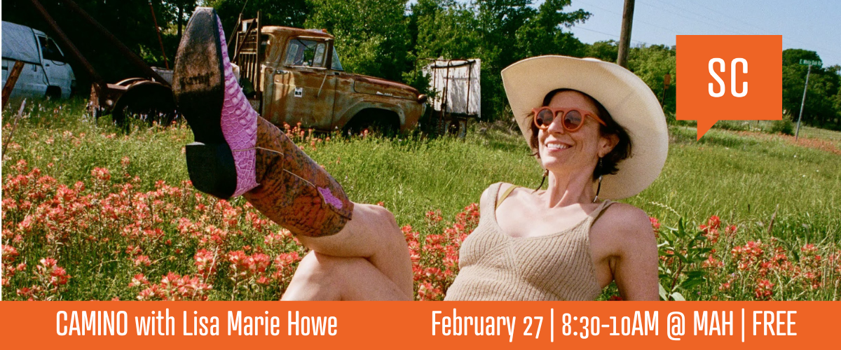 a woman with pink cowboy boots and a straw hat reclines in a field
