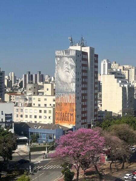 Me escrevo no caminho da terceira temporada em São Paulo. Um desejo antigo que virou realidade quando nem pensava mais que iria acontecer. Mas que veio para mostrar que agora a sede de conhecer tudo que ela tem a oferecer podia ser saciada com mais calma, mais tempo. Que tempo? Que inventei e sigo inventando. Na necessidade de criar momentos de respiro em meio ao turbilhão de mudanças e trabalho. 

Tive a sorte de encontrar um bairro para chamar de lar, a Barra Funda, onde encontrei as conexões com meu lugar no mundo, em Salvador, o Rio Vermelho. Esses dois bairros me escolheram pelo mar, pelo elevado, pela música. Vim parar justamente no ponto da nova efervescência cultural de SP, onde Mário de Andrade viveu e virou nome de avenida. Reduto da transformação industrial e do samba (onde tem riso, ritmo da música e resistência humana em tempos difíceis), dos bares e restaurantes. Do início do Minhocão que atravessa as veias do centro da cidade e é possível enxergar um horizonte de prédios e murais de artistas visuais nas empenas. Onde eu me encontro na falta do mar do meu RV, onde trabalhei, morei, festejei, saudei e continuo agradecendo a Yemanjá, onde aprendi a ter meu próprio espaço e nadei muito para chegar aqui. 

Sigo nadando, com vista para a frase inspiradora do mestre nordestino Paulo Freire. É preciso muito amor à vida, à mim mesma, aos meus, à cultura, às artes, às diversas formas de expressão que nos sensibiliza para levantar todo dia em busca do bem-estar, da realização dos nossos planos e sonhos sem perder a sensibilidade e os valores inegociáveis. 

Vou compartilhando aqui as felizes descobertas nesse caos de ansiedade e inspiração, com um olhar menos cinza da cidade. Serendipdade. 
Espero que goste. 

Nas fotos: o mural em homenagem ao educador e filósofo nordestino, Paulo Freire, no Edifício Santa Rosa, 348, na Praça Vicente Celestino, Barra Funda, São Paulo e a vista da Casa de Yemanjá, na Praia dos Pescadores, Rio Vermelho, Salvador-BA. #DoRVaBaFu #ReleaseDay2026