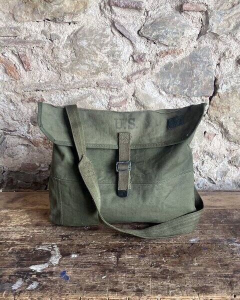 Another piece of te FoxtroBarcelona project. A medium-sized satchel bag made from fabric salvaged from a US Army M45 field pack. Features a US stencil on the front flap. Original fastening strap.
The internal markings from 1951 are clearly visible. Includes an inside pocket made from the waterproof lining of the original M45 Field Cargo Pack. An ideal bag for carrying your everyday essentials in a casual style.

Approx- measurements:
Height: 32 cm.
Width: 38 cm.

Any stains or discolouration are due to the natural ageing and wear of the materials used. We wash and prepare all vintage fabrics before use.
We devote time and attention to detail in the creation of every unique Foxtrot Barcelona bag.

#ReleaseDay2026 @CreativeMorning @Creative.Quests

#ArmyStyle #Workwear #ReconstructedVintage #UsArmy #Boho